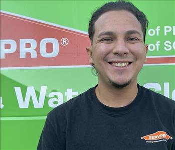 a man standing in front of the SERVPRO van 