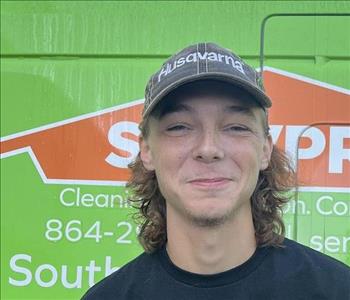 stryder a man standing in front of a green SERVPRO van